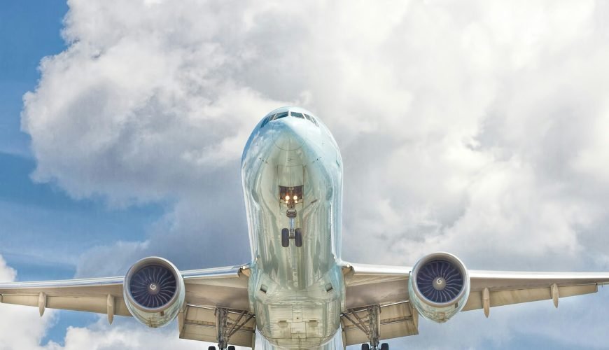 gray and white airplane on flight near clear blue sky